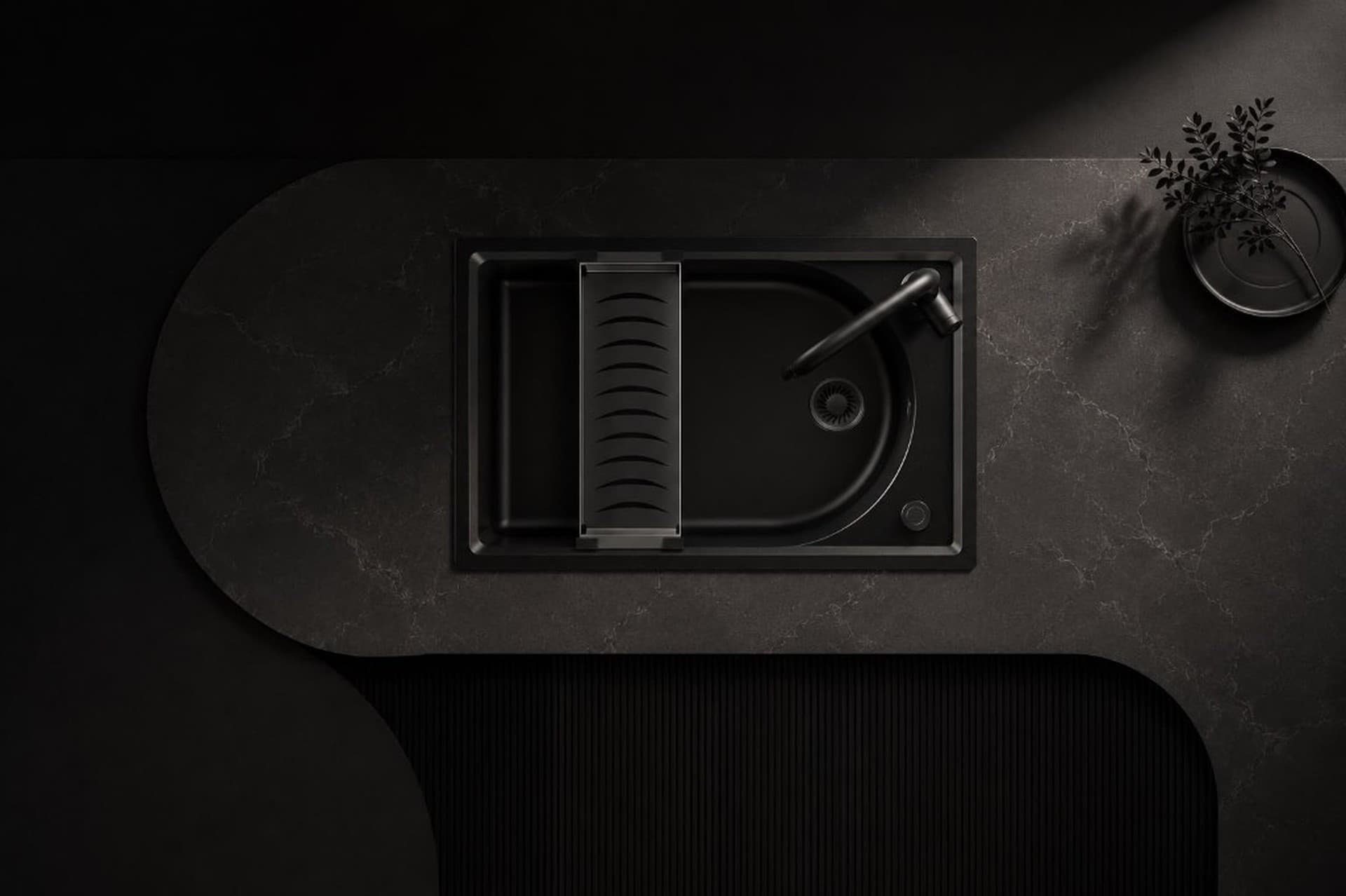Carysil black granite kitchen sink set into a dark stone counter